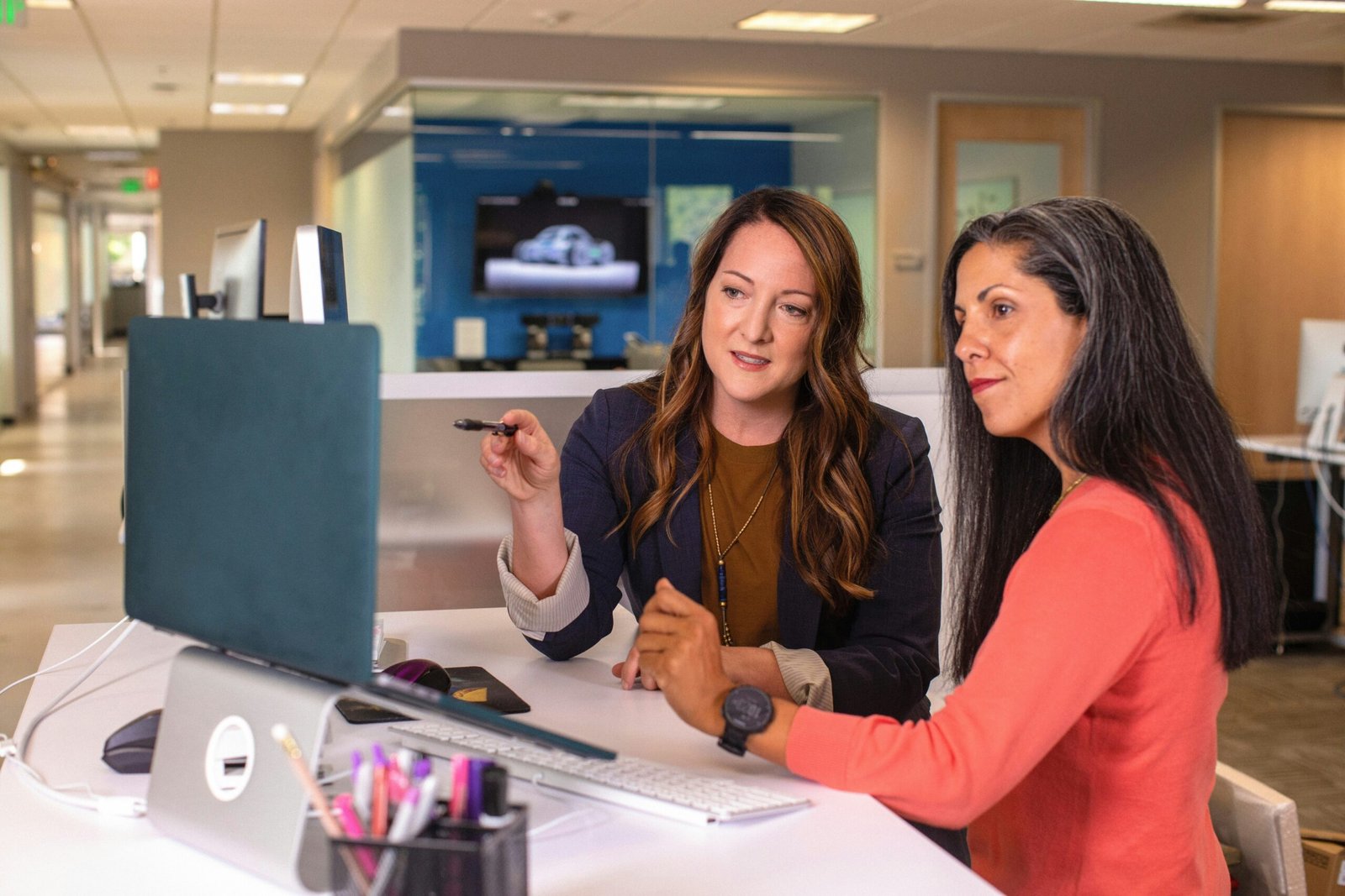 two women sitting at two women sitting at a table looking at a computer screen